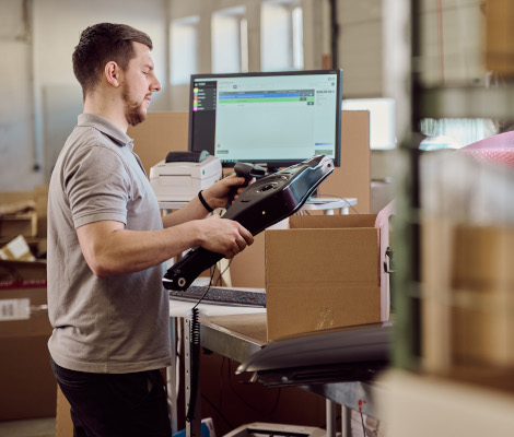 Ein Mitarbeiter vom Autoteile Service scannt ein Produkt ein